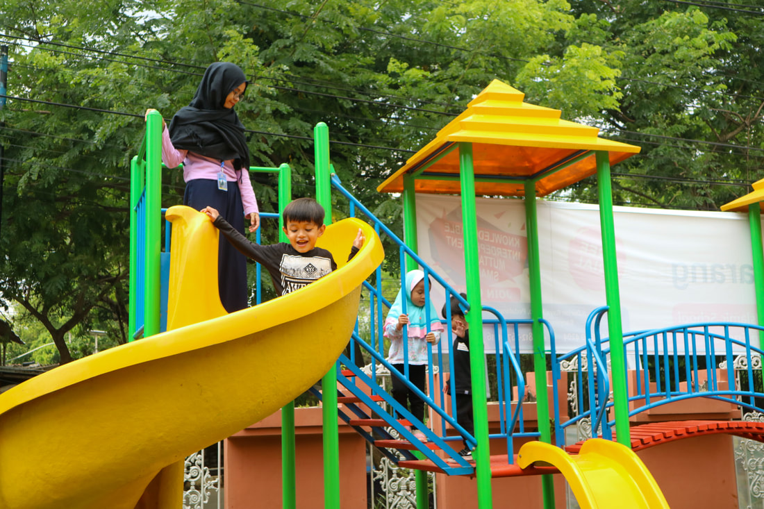 Students playing in the playground with the teachers